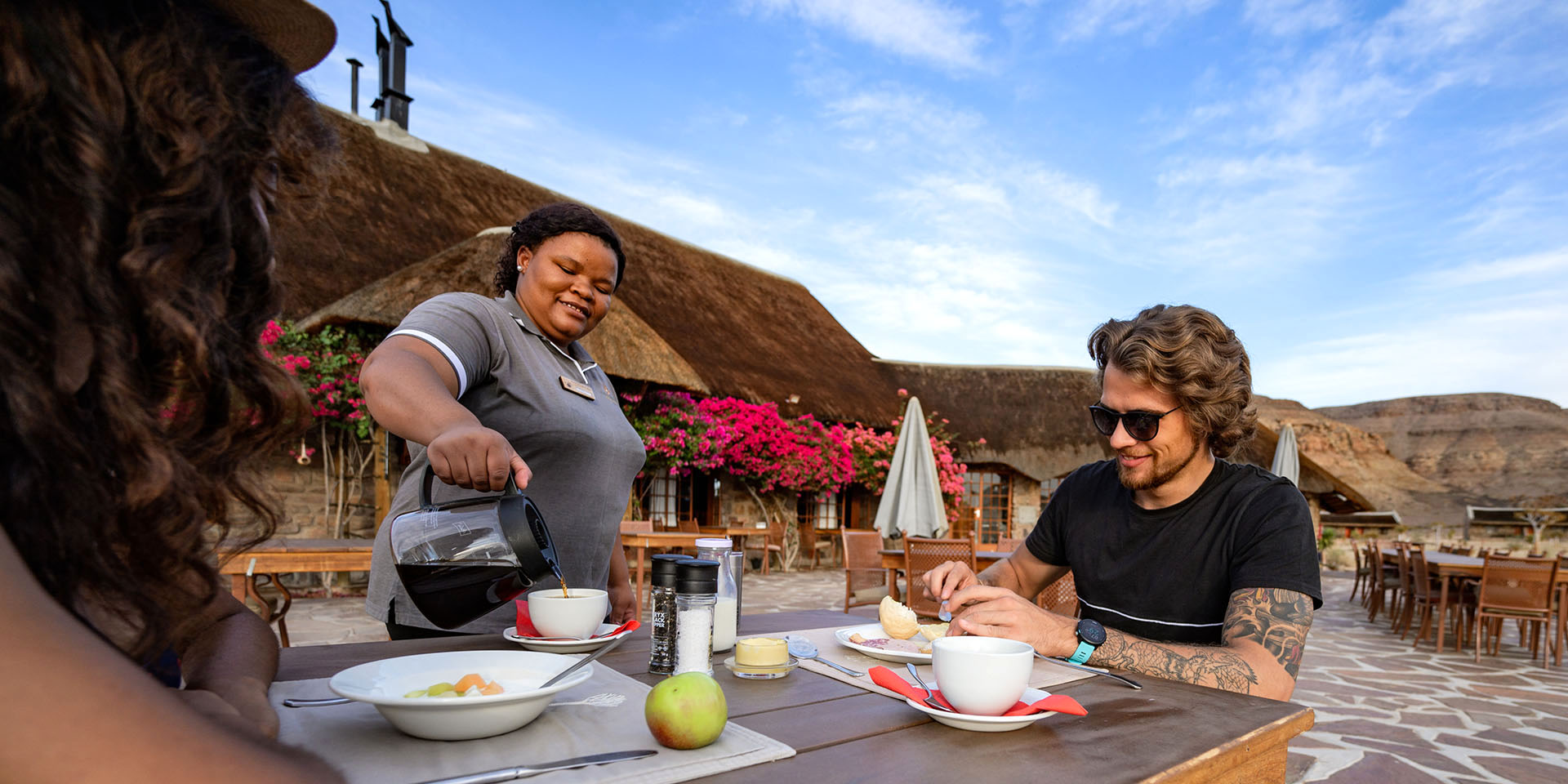 Serving coffee to two guests, Namibia